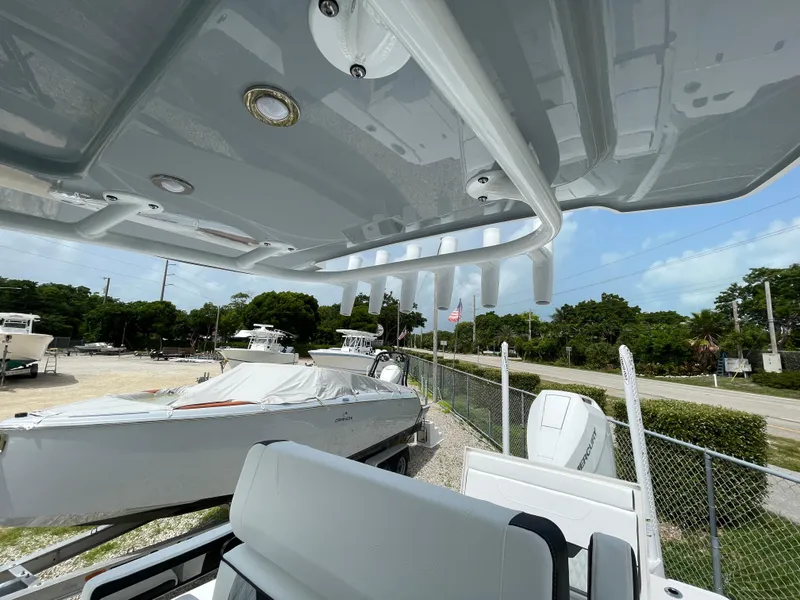 Slide: The Image of 2026 Blackfin 262 HB boat with covered deck and rod holders, parked outdoors. - 21