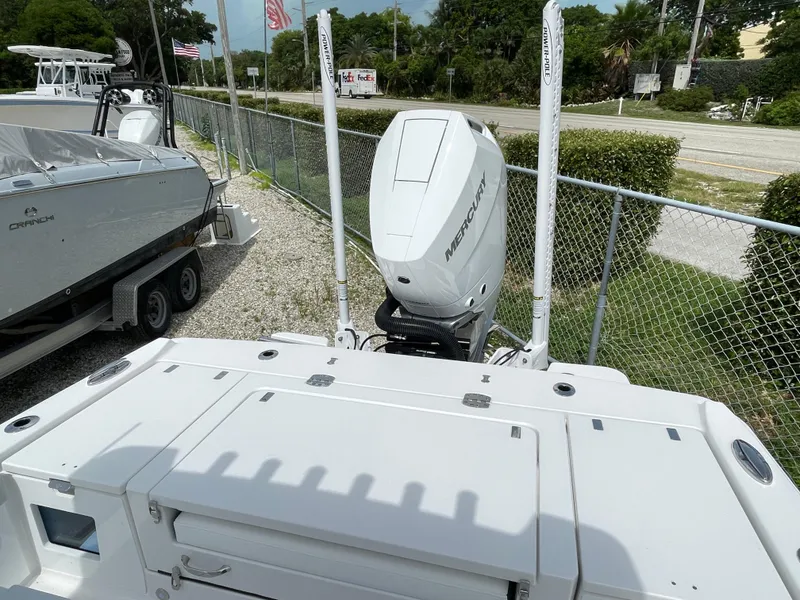 Slide: The Image of 2026 Blackfin 262 HB boat with Mercury engine, parked near a fence. - 36
