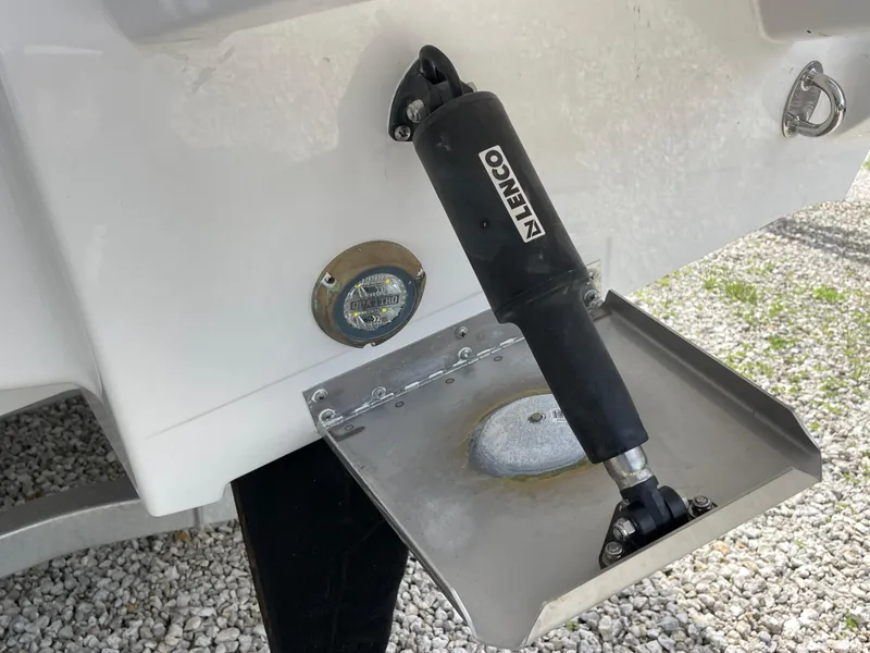 Slide: The Image of 2026 Blackfin 262 HB boat trim tab with Lenco actuator on gravel surface. - 38
