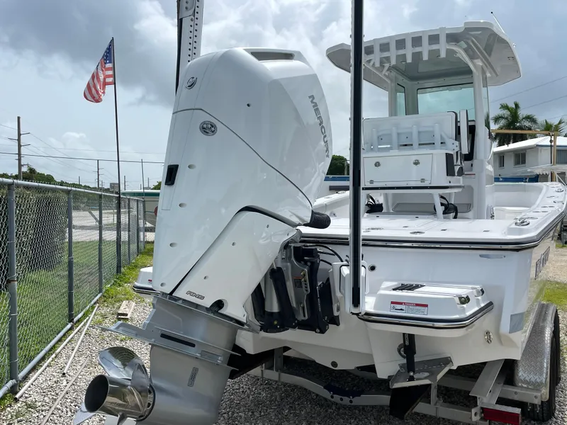 Slide: The Image of 2026 Blackfin 262 HB boat with Mercury engine, parked near a fence and American flag. - 40