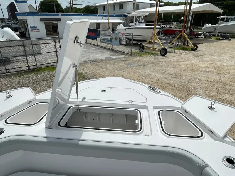 Slide: The Image of 2026 Blackfin 262 HB boat with open storage compartments at a marina. - 6