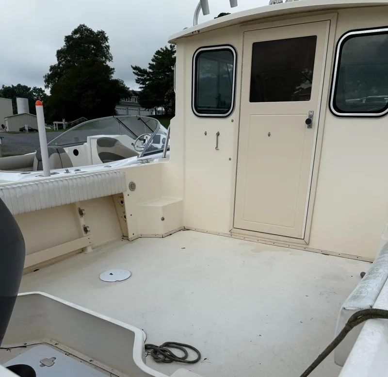 Slide: The Image of 2013 Parker 2120 SC boat deck with cabin door and seating area. - 4