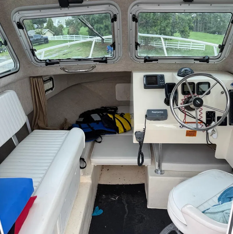 Slide: The Image of Interior of a 2013 Parker 2120 SC boat with steering wheel and seating. - 5