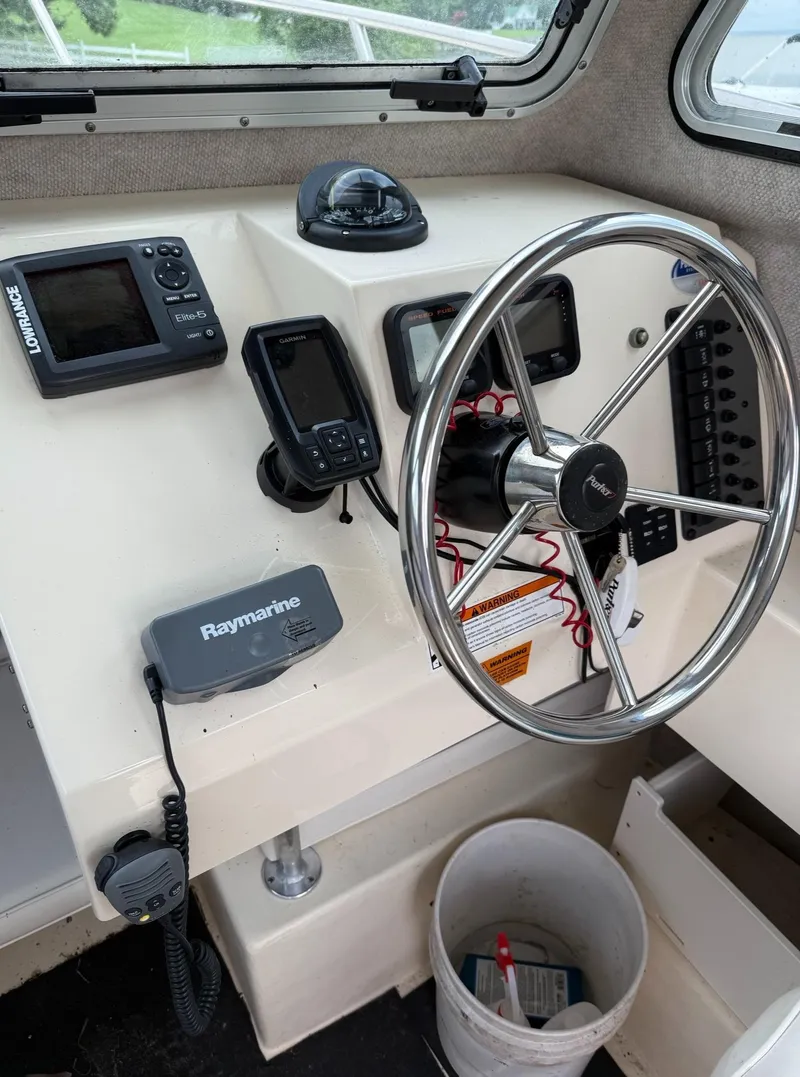 Slide: The Image of 2013 Parker 2120 SC boat dashboard with steering wheel and navigation equipment. - 6