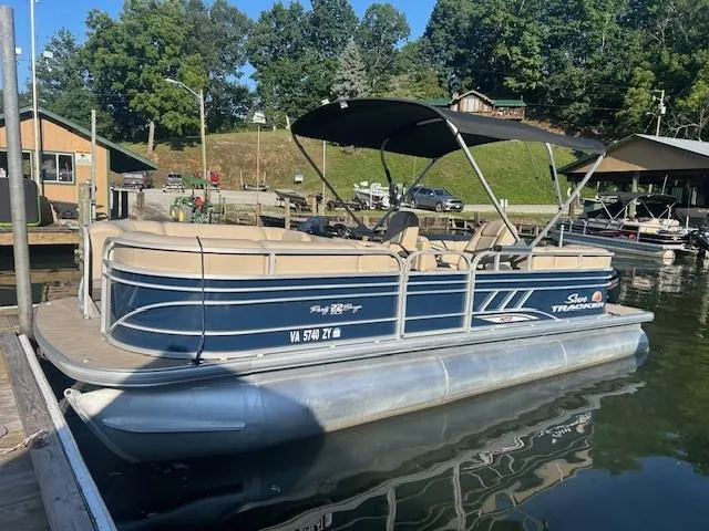 Slide: The Image of 2022 Sun Tracker Party Barge 22 XP3 pontoon boat docked by a lakeside cabin. - 14
