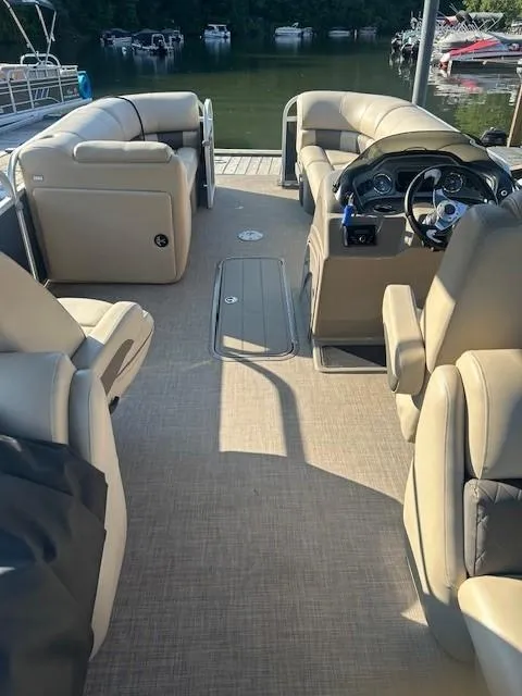 Slide: The Image of 2022 Sun Tracker Party Barge 22 XP3 interior with beige seating and steering console. - 22