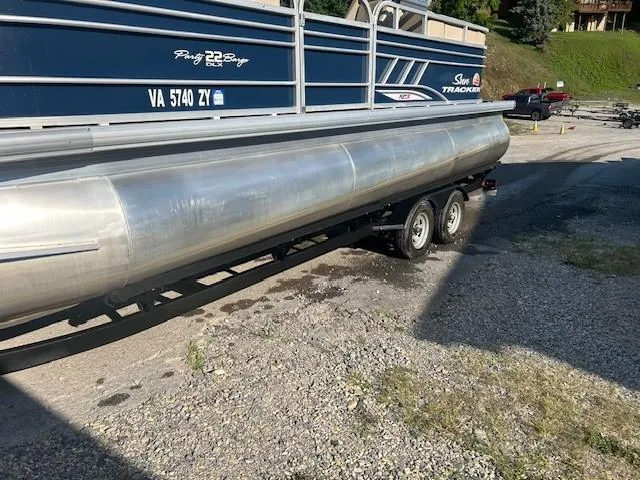 Slide: The Image of 2022 Sun Tracker Party Barge 22 XP3 pontoon boat on trailer, parked on gravel. - 24