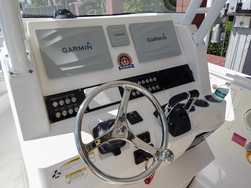 Slide: The Image of 2015 Edgewater 320CC boat dashboard with Garmin navigation system and steering wheel. - 11