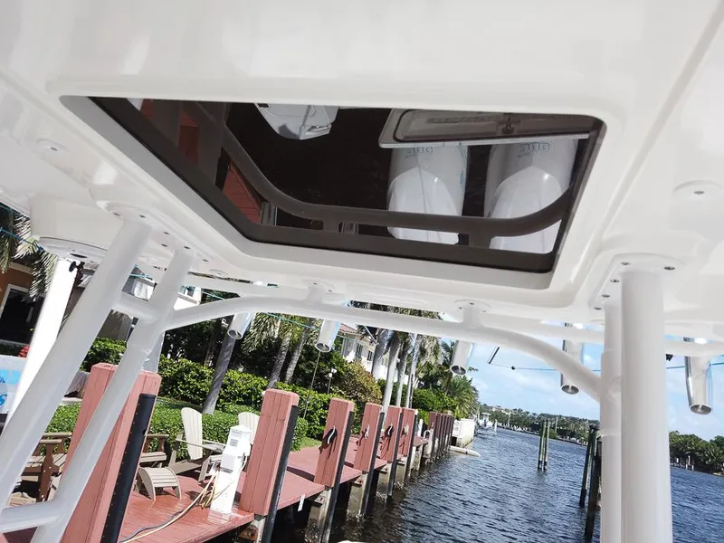 Slide: The Image of 2015 Edgewater 320CC boat detail with dockside view and palm trees. - 17