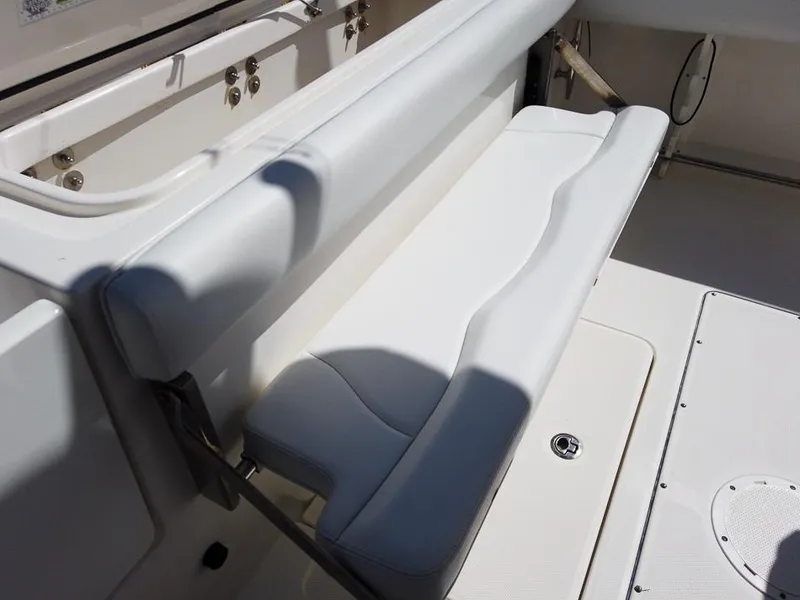 Slide: The Image of 2015 Edgewater 320CC boat with white cushioned seating and storage compartment. - 7