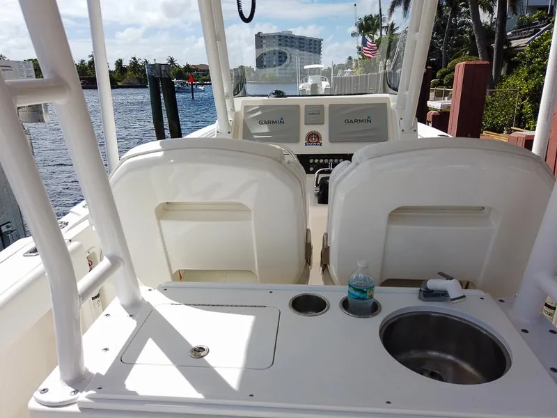 Slide: The Image of 2015 Edgewater 320CC boat interior with Garmin navigation, sink, and seating. - 9