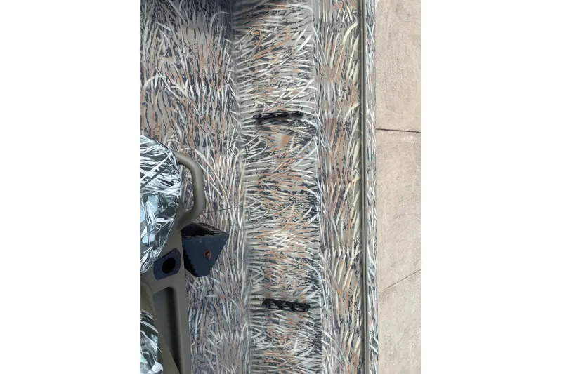 Slide: The Image of 2025 Tracker Grizzly 2072 CC boat interior with camouflage pattern design. - 11