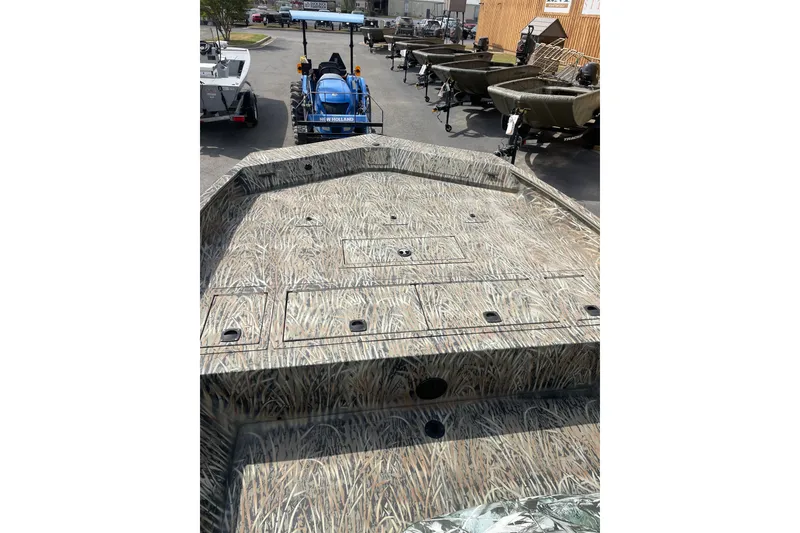 Slide: The Image of 2025 Tracker Grizzly 2072 CC boat with camouflage design, parked outdoors. - 14