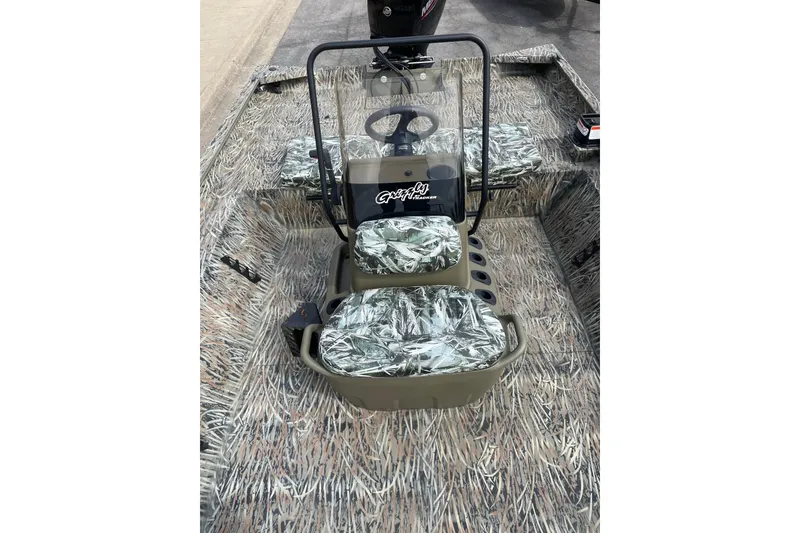 Slide: The Image of 2025 Tracker Grizzly 2072 CC boat interior with camouflage seating and steering console. - 15