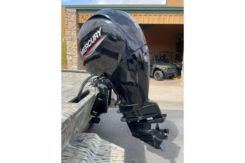 Slide: The Image of 2025 Tracker Grizzly 2072 CC with Mercury outboard motor, parked outdoors. - 5