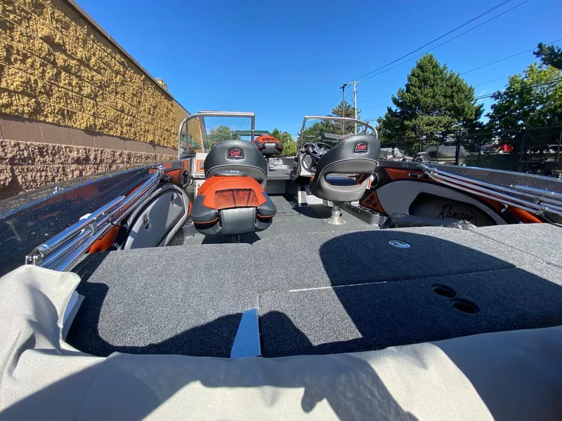 Slide: The Image of 2025 Ranger 1850MS boat interior with seating and steering, parked outdoors under clear blue sky. - 4
