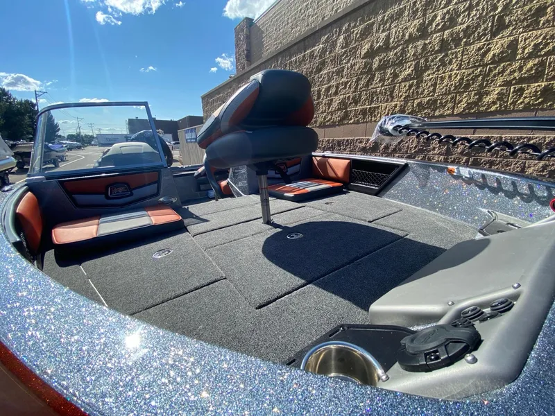 Slide: The Image of 2025 Ranger 1850MS boat interior with seating and storage, under a clear blue sky. - 5