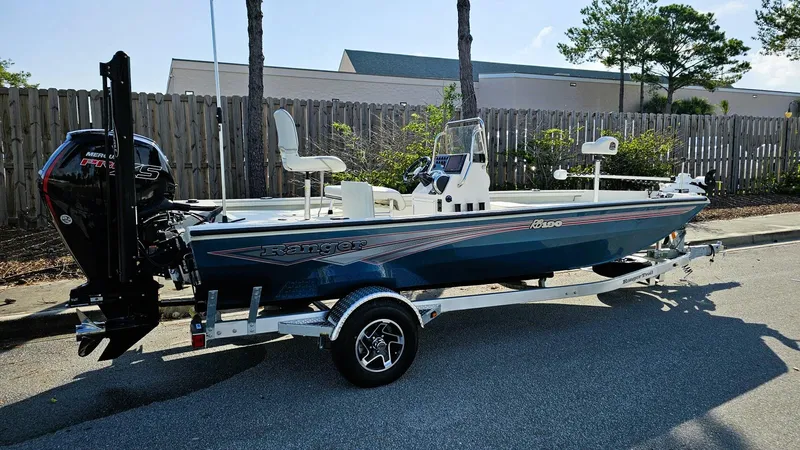 The Image of 2025 Ranger RB190 boat on trailer, parked outdoors, featuring a sleek design and powerful engine. - 0