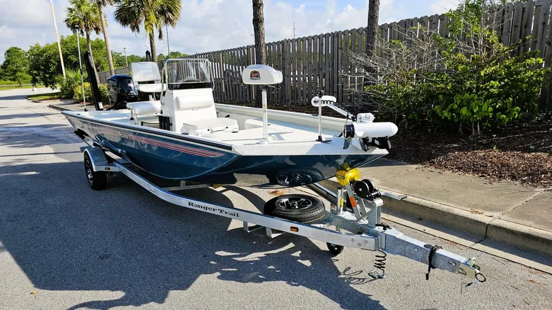 Slide: The Image of 2025 Ranger RB190 boat on trailer, parked outdoors near palm trees. - 5