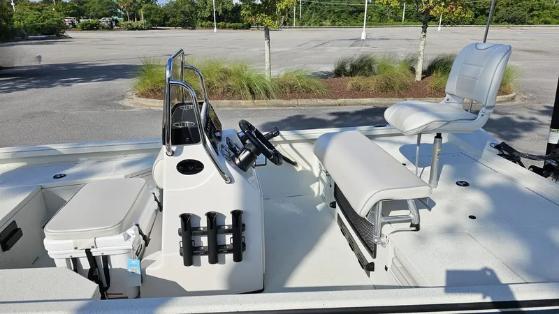 Slide: The Image of 2025 Ranger RB190 boat interior with seating and steering console in a parking lot. - 8