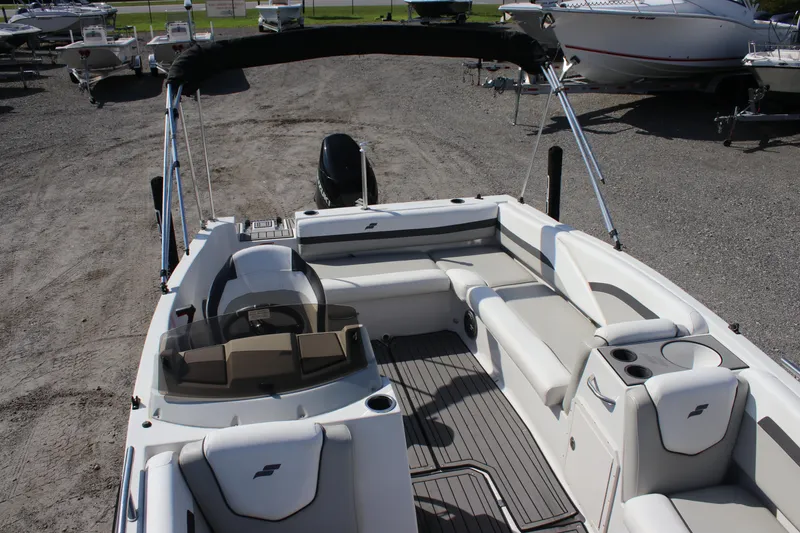 Slide: The Image of 2021 Starcraft SVX 191 OB boat interior with seating and steering wheel, parked on gravel. - 15