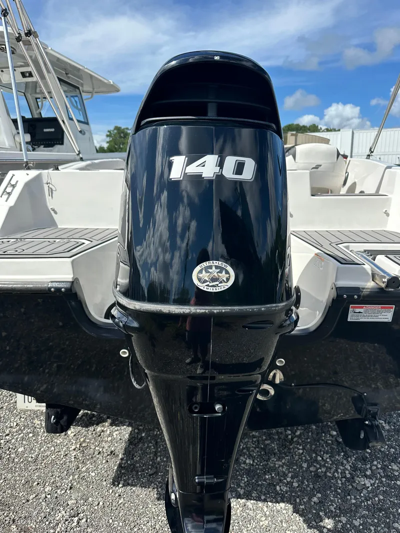 Slide: The Image of Outboard motor on 2021 Starcraft SVX 191 OB boat, labeled "140," under blue sky. - 17