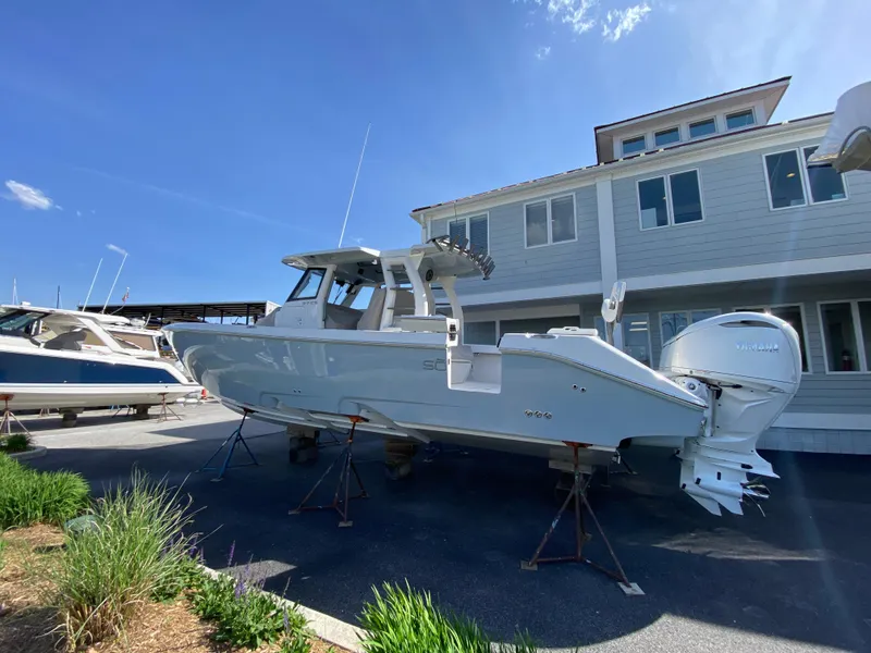 Slide: The Image of 2025 Solace 37 CS boat on stands, near a building, under clear blue sky. - 1