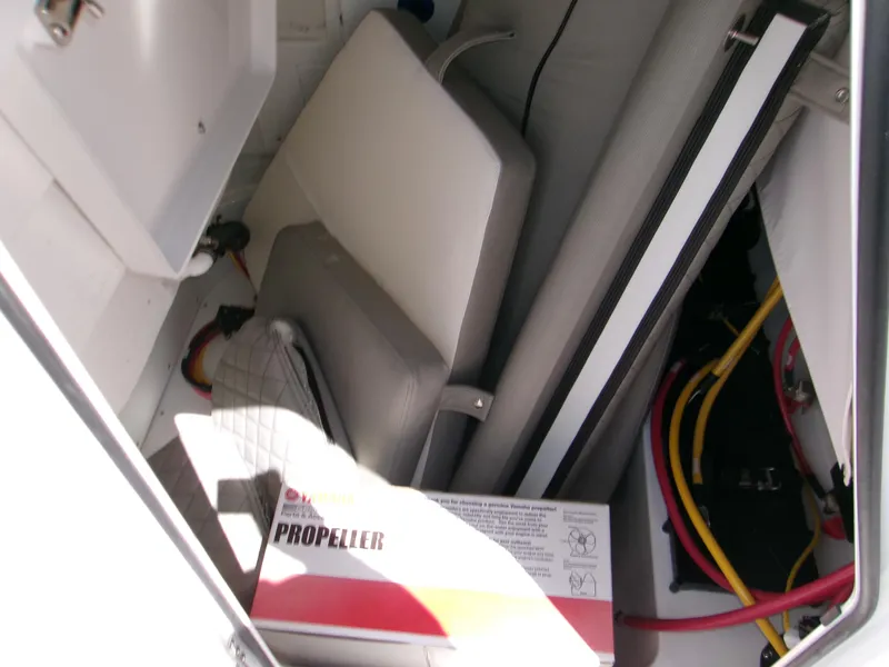 Slide: The Image of Storage compartment of 2026 Sportsman Open 232 Center Console with propeller box and cables. - 13