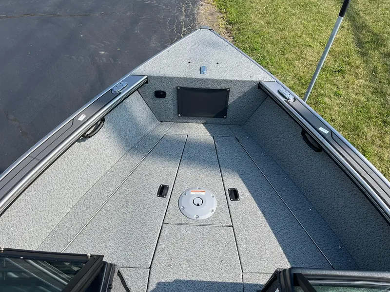 Slide: The Image of 2026 Lund 2075 Fisherman boat interior with gray flooring and storage compartments. - 14