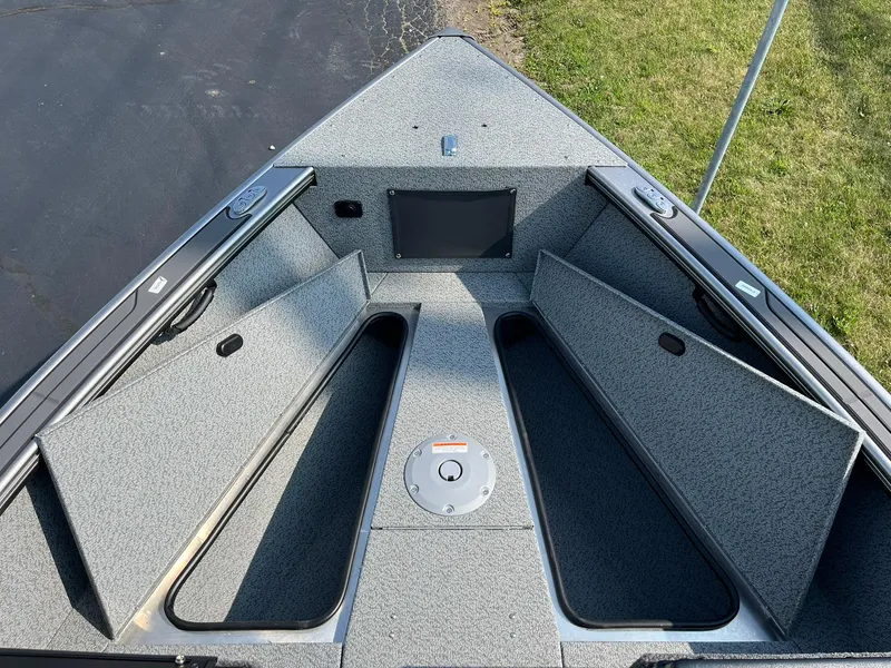 Slide: The Image of 2026 Lund 2075 Fisherman boat interior with open storage compartments and carpeted deck. - 15