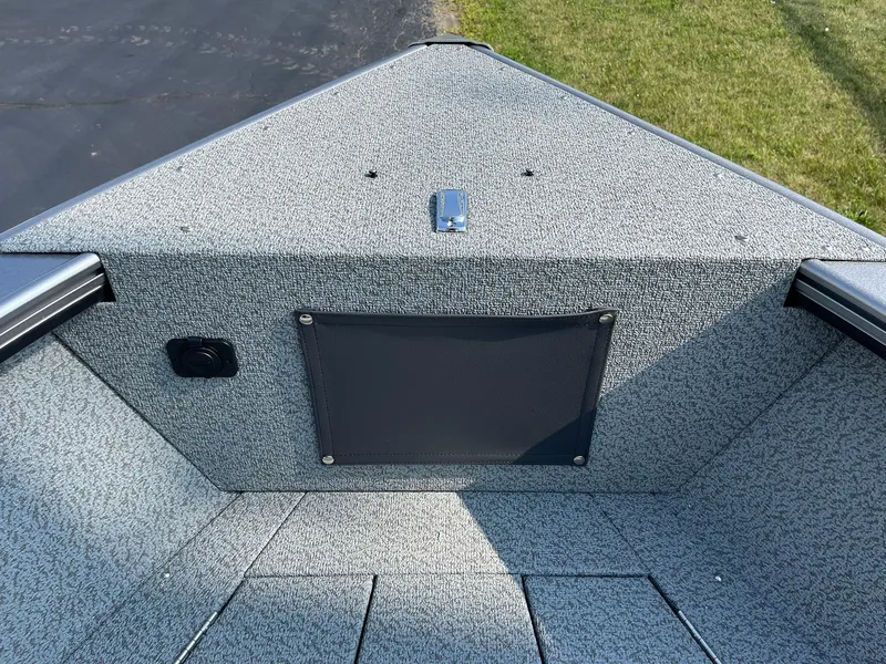 Slide: The Image of Interior view of 2026 Lund 2075 Fisherman boat, featuring textured flooring and storage compartment. - 16