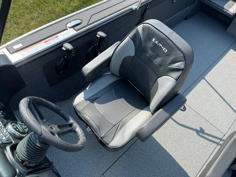 Slide: The Image of 2026 Lund 2075 Fisherman boat interior with steering wheel and cushioned seat. - 19