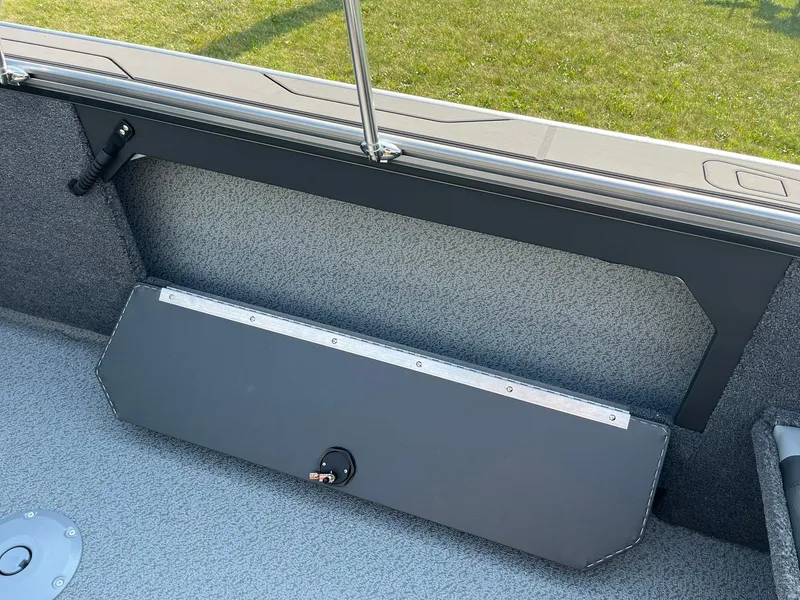 Slide: The Image of 2026 Lund 2075 Fisherman boat interior with storage compartment and textured flooring. - 28