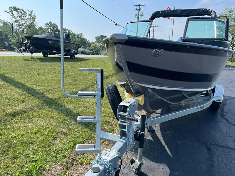 Slide: The Image of 2026 Lund 2075 Fisherman boat on trailer, parked on grass, sunny day. - 3