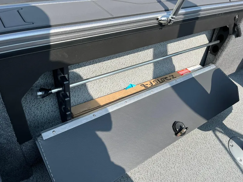 Slide: The Image of 2026 Lund 2075 Fisherman boat interior with storage compartment and metal rod holders. - 31