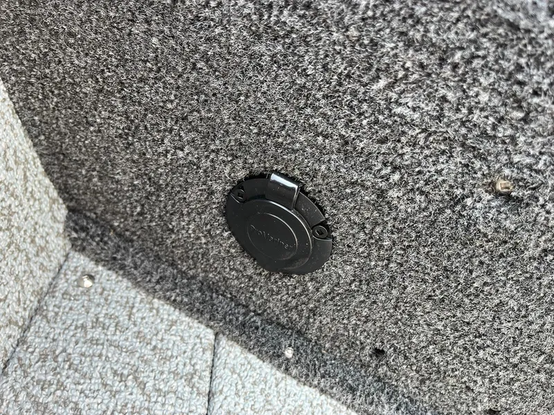 Slide: The Image of 2026 Lund 2075 Fisherman boat interior with carpeted surface and a circular black port. - 36