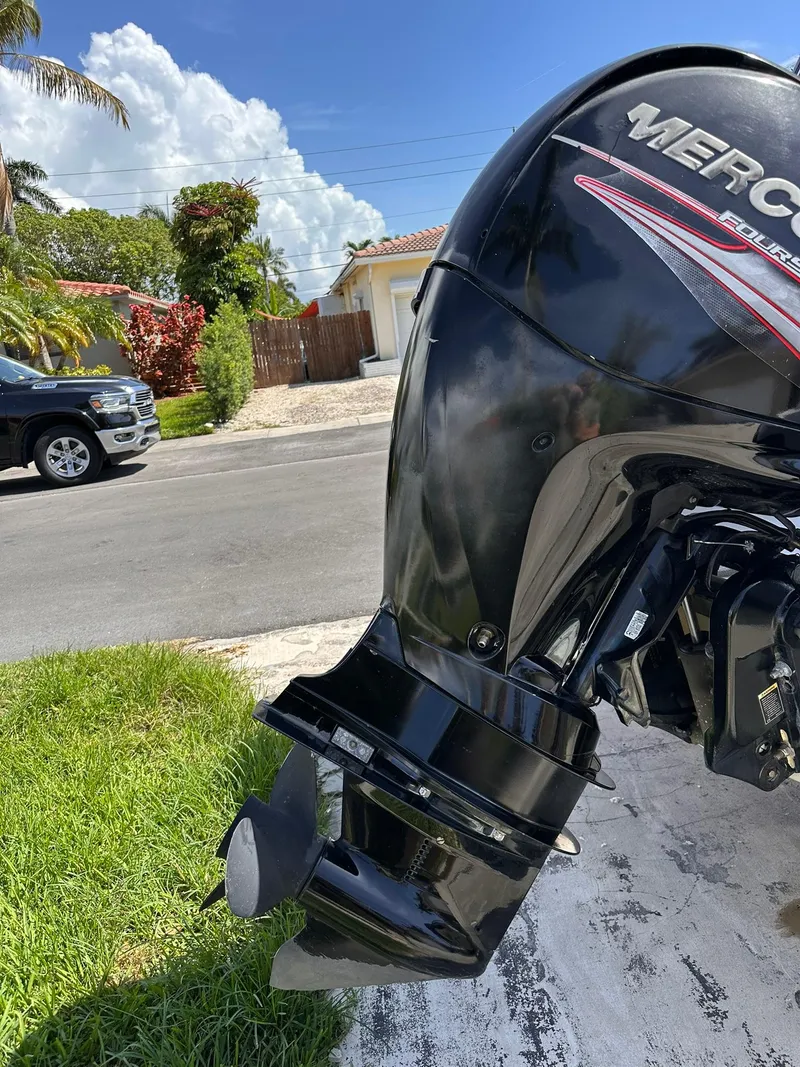 Slide: The Image of Outboard motor of a 2001 Bayliner 215 Deck Boat, parked in a sunny residential area. - 5