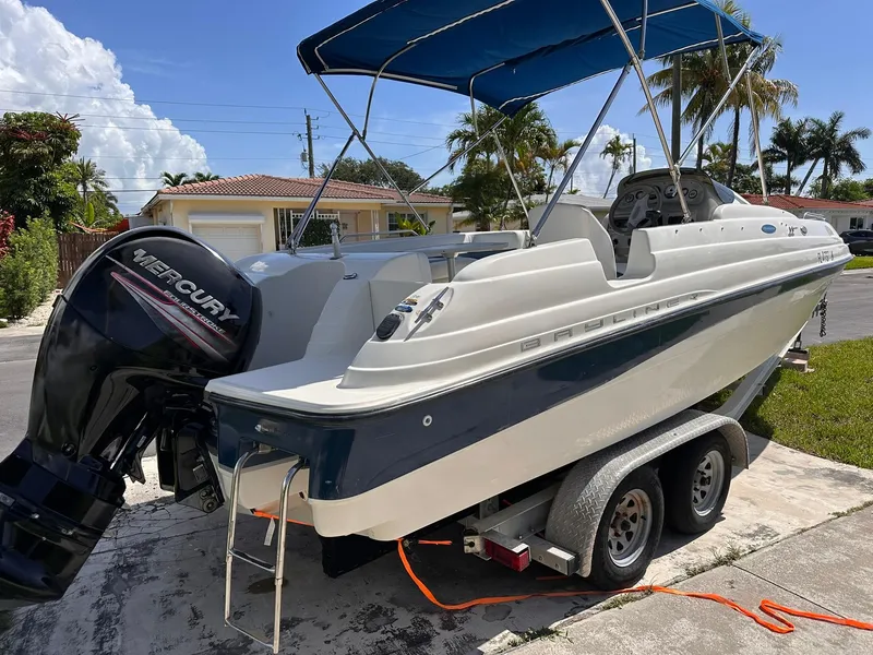 Slide: The Image of 2001 Bayliner 215 Deck Boat with Mercury engine on trailer, parked in residential area. - 6
