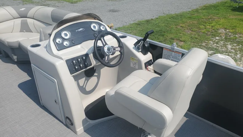 Slide: The Image of 2020 Starcraft EX 22 Q boat interior with steering console and seating. - 3