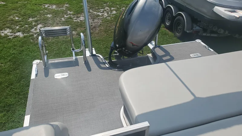 Slide: The Image of 2020 Starcraft EX 22 Q boat with outboard motor and swim ladder on grass. - 4