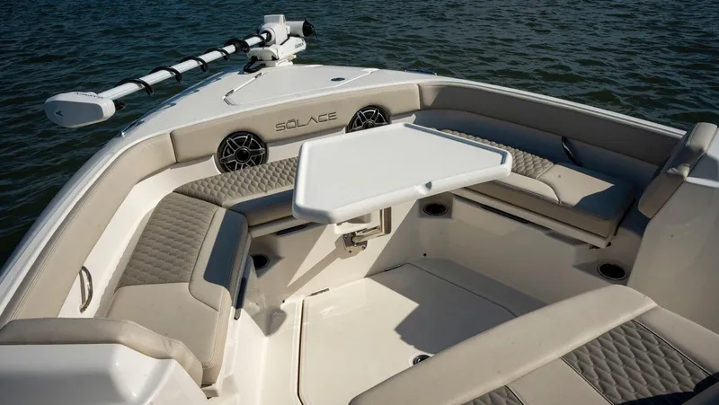 Slide: The Image of 2025 Solace 28 HCS boat interior with seating and table on water. - 4