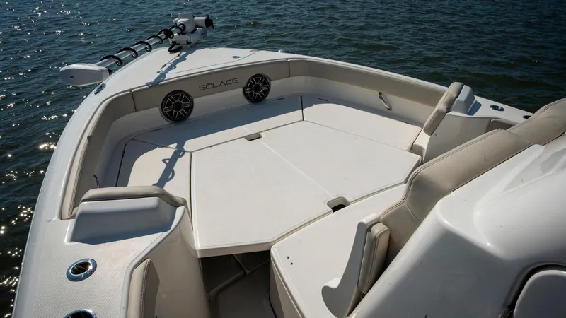 Slide: The Image of 2025 Solace 28 HCS boat interior with spacious seating on calm water. - 5