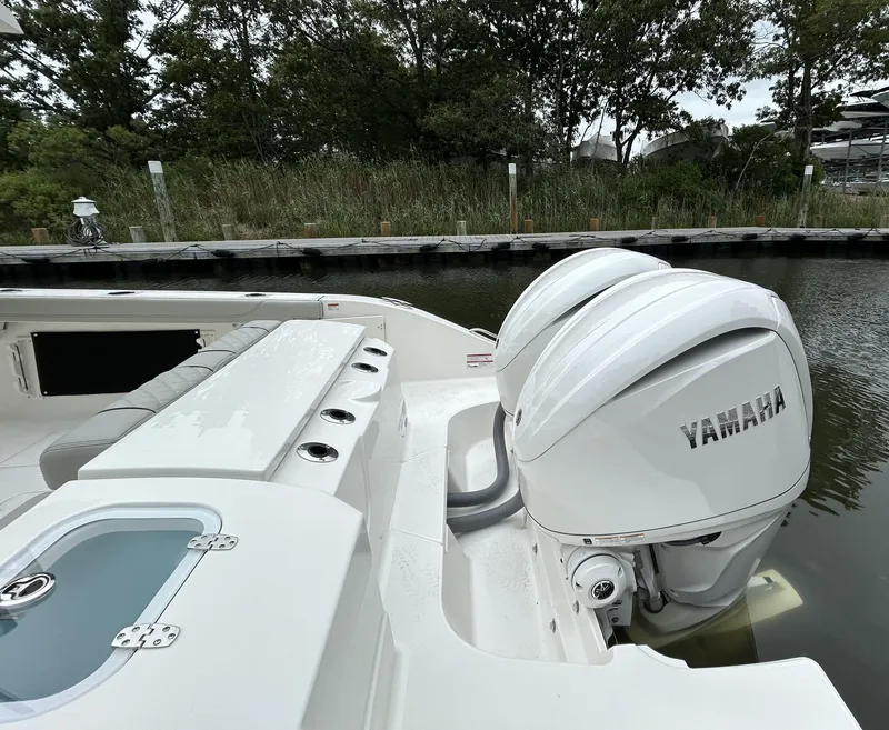 Slide: The Image of 2026 Pursuit S 288 boat with Yamaha engines docked by a wooded shoreline. - 5