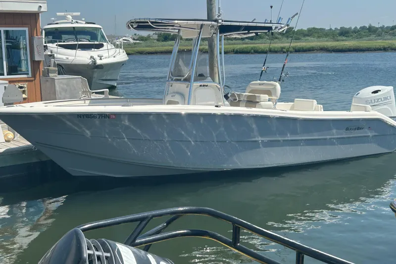 The Image of 2024 Bulls Bay 230 CC boat docked, featuring a sleek design and Suzuki outboard motor. - 0