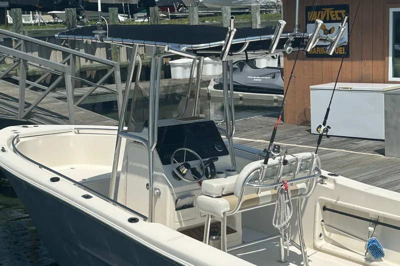 Slide: The Image of 2024 Bulls Bay 230 CC boat docked with fishing rods and console view. - 2