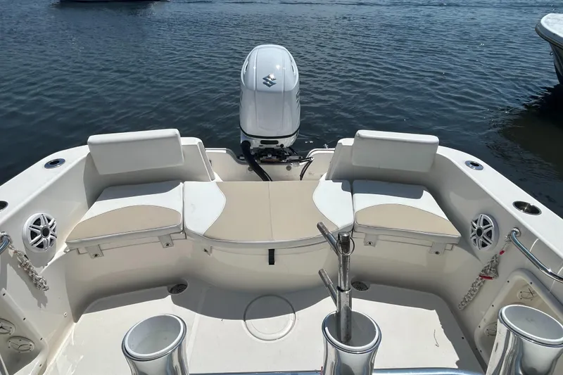 Slide: The Image of 2024 Bulls Bay 230 CC boat interior with seating and outboard motor on water. - 5