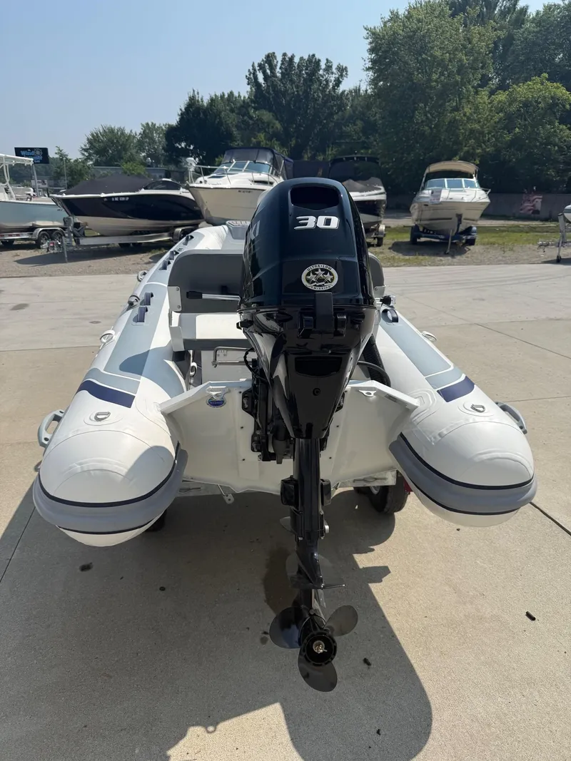 Slide: The Image of 2024 Highfield Classic 360 GT inflatable boat with 30 HP outboard motor, parked on concrete. - 4