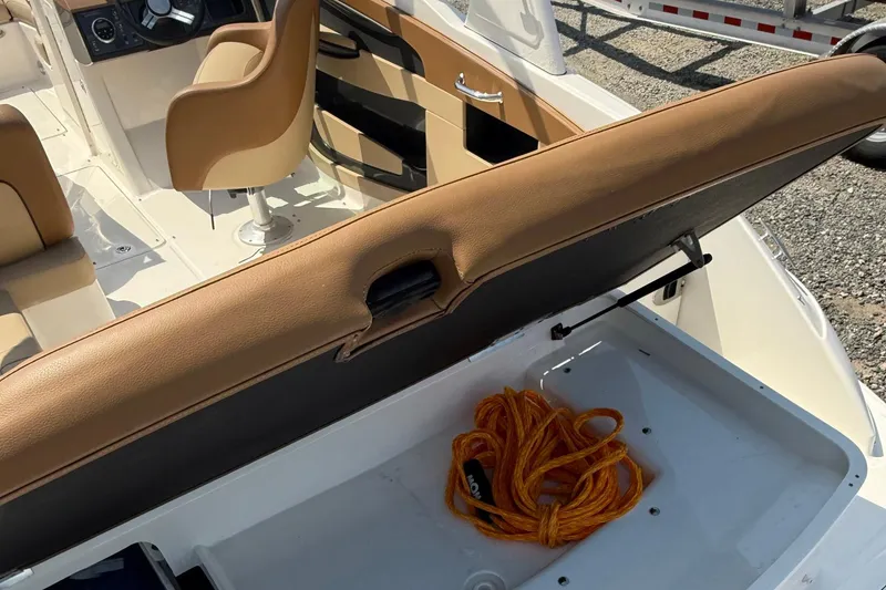 Slide: The Image of 2014 Sea Ray 240 Sundeck Outboard interior with storage compartment and orange rope. - 13