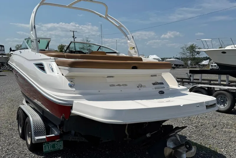 Slide: The Image of 2014 Sea Ray 240 Sundeck Outboard boat on trailer, parked outdoors under clear sky. - 15