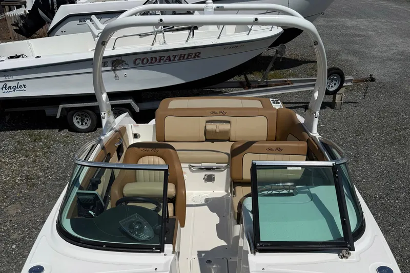 Slide: The Image of 2014 Sea Ray 240 Sundeck Outboard with tan seating, parked on gravel. - 5